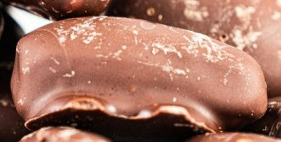 Nahaufnahme Vitinor Datteln mit Schokoladenüberzug. Premium Snack mit weichen Datteln und zarter Schokolade – ideal für bewusste Naschmomente und gesunde Genussmomente.