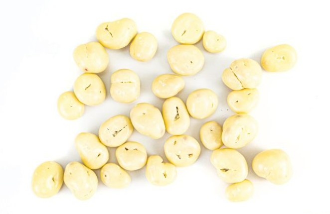 Vitinor weiße Joghurt-überzogene Cranberries flach arrangiert. Nährstoffreicher Snack, ideal für bewusste Ernährung, gesunde Zwischenmahlzeiten und hochwertige Geschenkboxen.